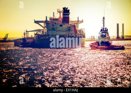 Tanker Schiff mit Schleppern am Meer. Vintage getönten Foto. Stockfoto