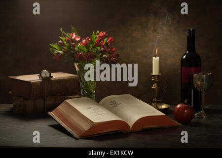 Stillleben mit eine aufgeschlagene Bibel-Wörterbuch auf einem Tisch mit einer Kerze, Wein Flasche und Becher, Apfel und Pocket watch Stockfoto