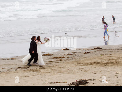 Braut und Bräutigam zu Fuß am Strand Stockfoto