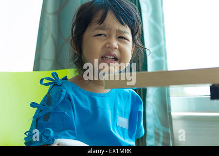 Krankheit asiatischen Kinder weinen, sitzen auf einem Stuhl im Krankenhaus, Kochsalzlösung intravenös (IV) auf Seite Stockfoto