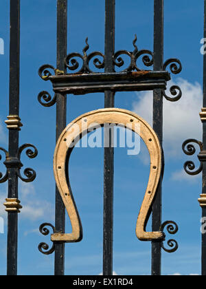 Golden Horseshoe auf dem schwarzen schmiedeeisernen Toren von Oakham Castle, mit blauem Himmel über, Oakham, Rutland, England, UK. Stockfoto