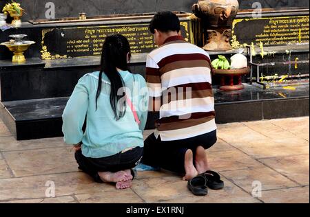 Chiang Mai, Thailand zwei Gläubige barfuß Thais Knien im Gebet an ein Outdoor-Schrein im Wat Suan Dok Stockfoto