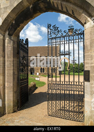 Schmiedeeiserne Tore mit goldenen Hufeisen am Eingang Oakham Castle mit Oakham Burgsaal darüber hinaus, Rutland, England, UK. Stockfoto