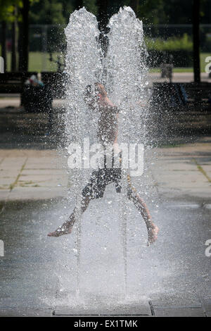 Berlin, Deutschland. 4. Juli 2015. Ein Kind spielt in einem Brunnen in Berlin, Deutschland, am 4. Juli 2015. Die Temperatur in Berlin erreicht bis zu 38 Grad Celsius am Samstag. Bildnachweis: Zhang Fan/Xinhua/Alamy Live-Nachrichten Stockfoto