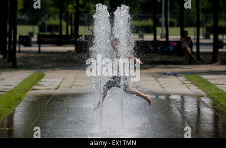 Berlin, Deutschland. 4. Juli 2015. Ein Kind spielt in einem Brunnen in Berlin, Deutschland, am 4. Juli 2015. Die Temperatur in Berlin erreicht bis zu 38 Grad Celsius am Samstag. Bildnachweis: Zhang Fan/Xinhua/Alamy Live-Nachrichten Stockfoto