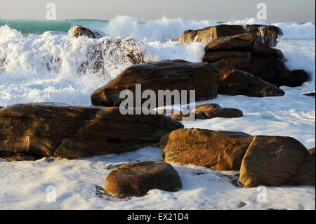 Durban, KwaZulu-Natal, Südafrika, weißer Schaum, brechenden Welle waschen über Felsen im goldenen Licht des frühen Morgens, Landschaft, Strand Stockfoto