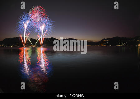 Feuerwerk an der Seepromenade von Luino in einem schönen Sommerabend, Varese - Lombardei, Italien Stockfoto