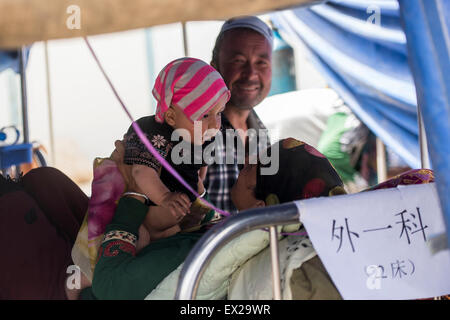 Pishan, Chinas Xinjiang Uygur Autonome Region. 5. Juli 2015. Eine verletzte Frau erfüllt ihre Familienmitglieder in einem provisorischen Zelt Krankenhaus in Erdbeben betroffenen Pishan Grafschaft, Nordwesten Chinas Xinjiang Uygur Autonome Region, 5. Juli 2015. Eine Erdbeben der Stärke 6,5 getroffen Pishan am Freitag. Bisher gibt es drei bestätigte Todesfälle und 71 verletzt. Bildnachweis: Jiang Wenyao/Xinhua/Alamy Live-Nachrichten Stockfoto