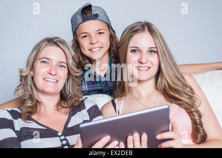 Motherdigital Tablet beim Sitzen auf dem Sofa zu Hause Stockfoto