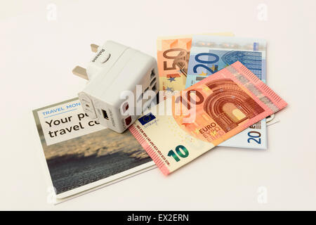 International Travel Plug und Euro-banknoten isoliert auf weißem Hintergrund Stockfoto