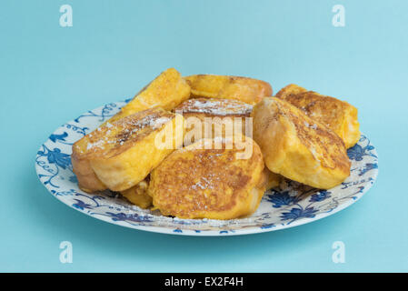 Ein Teller mit French Toast auf einen weiß und blau floral gestaltet-Platte auf einem hellblauen Hintergrund. Stockfoto