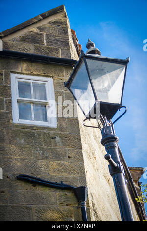 Straßenlaterne vor einem alten Steingebäude in Robin Hoods Bay positioniert Stockfoto