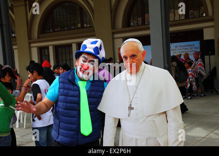 La Paz, Bolivien, 5. Juli 2015. Ein Clown posiert mit einem lebensgroßen Karton-Ausschnitt von Papst Franziskus bei einer Veranstaltung, um seinen bevorstehenden Besuch in Bolivien zu feiern. Papst Franziskus wird La Paz am 8. Juli während seiner 3-tägigen Reise nach Bolivien besuchen. Stockfoto