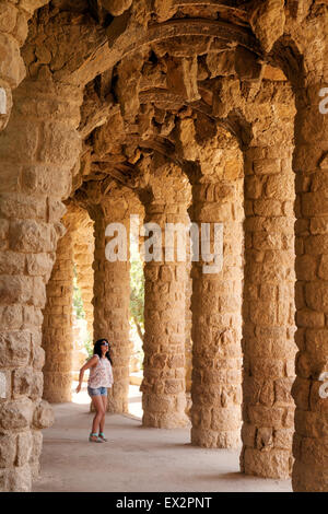 Ein Tourist unter den Bögen im Park Güell (Parc Güell), entworfen von Antoni Gaudi, Barcelona, Spanien-Europa Stockfoto