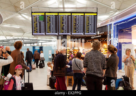 Personen an der Abfahrtstafel, Abflughalle, Stansted Flughafen, Essex UK Stockfoto