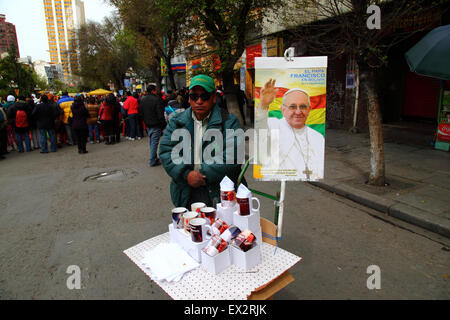 La Paz, Bolivien, 5. Juli 2015. Ein Mann verkauft Papst Franziskus Becher auf einer Straße auf der Avenida 16 de Julio/El Prado stall in er Innenstadt. Papst Franziskus besuchen La Paz am 8. Juli während seines 3-tägigen Reise nach Bolivien. Stockfoto