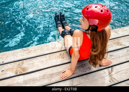 Frau in Sportkleidung mit skating Rollen auf dem pier Stockfoto