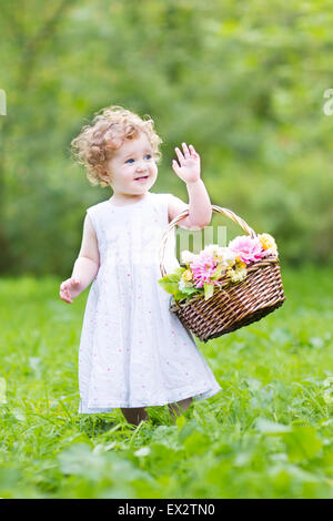 Lustige Kleinkind Mädchen spielen mit einem Blumenkorb am Ostermorgen Stockfoto