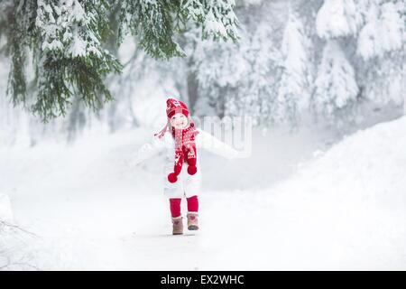 Lustig Lachen Kleinkind Mädchen laufen in einem schönen verschneiten park Stockfoto