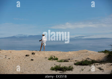 Eine Fotografin blickt auf eine Sanddüne auf Isla Santa Cruz auf den Galapagos Inseln. Stockfoto