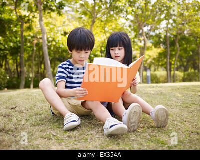 asiatische junge und Mädchen lesen in einem Park. Stockfoto