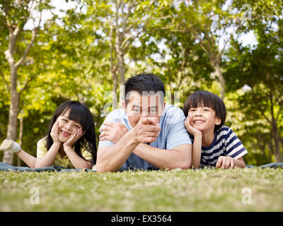 Vater und Kinder spielen im freien Stockfoto