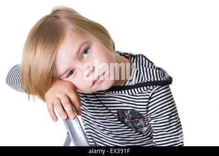 Kleiner Junge mit einem traurigen Gesicht in gestreiften Hemd und Haube in die Kamera schaut. Stockfoto