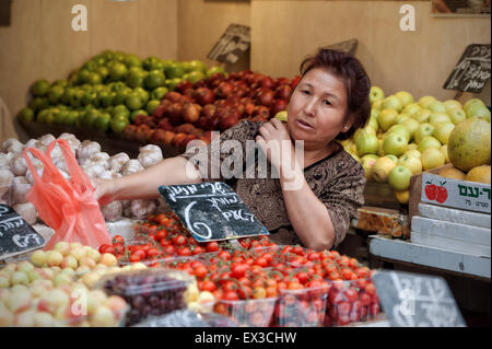 Einer erwachsenen Frau shopping für Produkte am Mahane Yehuda, Jerusalem, Israel Stockfoto