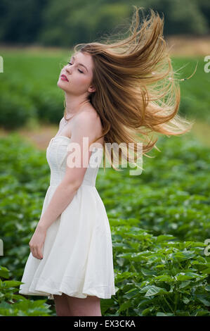 Eine junge Frau in einem grünen Feld, Haare im Wind wehen. Kibbutz Ha'solelim, Israel Stockfoto