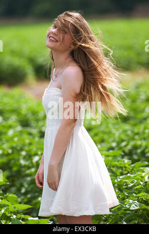 Eine junge Frau in einem grünen Feld, Haare im Wind wehen. Kibbutz Ha'solelim, Israel Stockfoto