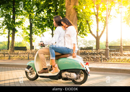 Junges Paar Motorroller in der Stadt Stockfoto