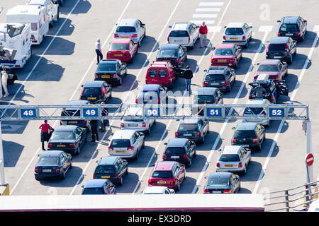 Der Hafen von Dover in England. Overhead fernen Schuss Reihen von geparkten Autos in hellem Sonnenlicht warten in Bahnen vor dem Einschiffen auf Kanal Fähre überqueren. Stockfoto