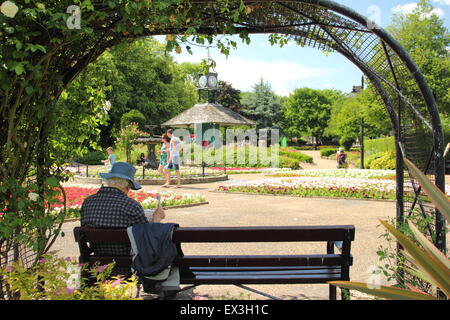 Ein Mann entspannt unter in Halle Leys Park, Matlock, Derbyshire Dales, England UK - Sommer Stockfoto