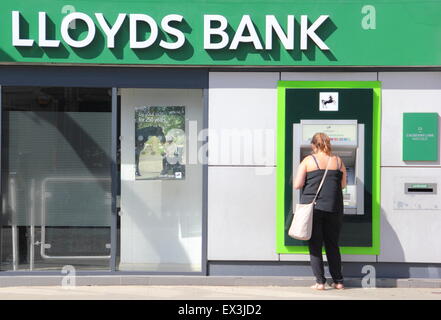 Eine Frau benutzt ein Geldautomat Cashpoint in der Lloyds Bank-Filiale in Derbyshire England UK Stockfoto