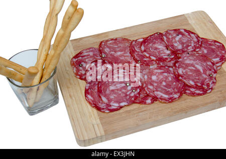 Scheiben Salami auf schneiden Board und Brot-Sticks auf weißem Hintergrund Stockfoto