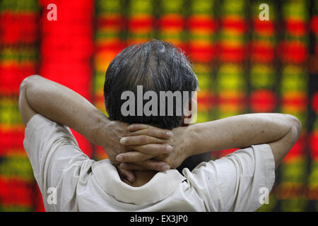 Der Provinz Anhui Huaibei, China. 6. Juli 2015. Ein Mann wacht ein Bildschirm-Brett auf einem Aktien-Markt in Huaibei, der ostchinesischen Provinz Anhui, 6. Juli 2015. Chinesische Aktien zeigte Anzeichen einer Stabilisierung am Montag mit der Benchmark Shanghai Composite Index 2,41 Prozent auf 3.775,91 Punkte zu beenden. Allerdings verlor der Shenzhen Komponente Index 1,39 Prozent auf 12.075,77 Punkte zu schließen. Der ChiNext Index, tracking Chinas Nasdaq-Stil Board wachsender Unternehmen, stürzte 4,28 Prozent bei 2.493,83 Punkten. Bildnachweis: Xie Zhengyi/Xinhua/Alamy Live-Nachrichten Stockfoto