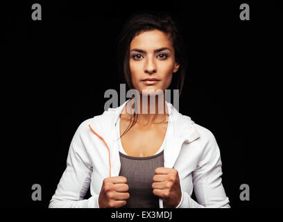 Aufnahme des jungen Fitness Model posiert im Studio. Gesunde junge Frau in Sportkleidung stehend auf schwarzem Hintergrund. Stockfoto
