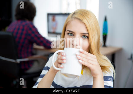 Casual Mädchen trinken Kaffee im Büro Stockfoto