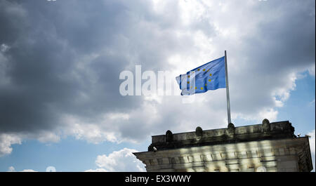 Berlin, Deutschland. 6. Juli 2015. Eine Flagge der Europäischen Union fliegt auf dem Dach des Reichstags, der deutsche Parlamentsgebäude mit dunklen Wolken schweben, in Berlin, Deutschland, 6. Juli 2015. Foto: Bernd von Jutrczenka/Dpa/Alamy Live News Stockfoto