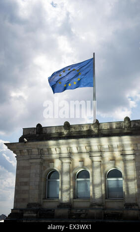 Berlin, Deutschland. 6. Juli 2015. Eine Flagge der Europäischen Union fliegt auf dem Dach des Reichstags, der deutsche Parlamentsgebäude mit dunklen Wolken schweben, in Berlin, Deutschland, 6. Juli 2015. Foto: Bernd von Jutrczenka/Dpa/Alamy Live News Stockfoto