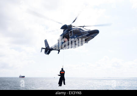 Ostsee bei Rostock-Warnemünde, Deutschland. 6. Juli 2015. Ein Polizeihubschrauber hisst zwei Crew-Mitglieder an einer Demonstration für Bundesinnenminister Thomas de Maizière an Bord eines deutschen Bundes-Polizei-Schiffes "Eschwege" in der Ostsee in der Nähe von Rostock-Warnemünde, Deutschland 6. Juli 2015. De Maizière hat einen besonderen Einblick in die Arbeit der Bundespolizei See während seines Besuchs. Foto: DANIEL BOCKWOLDT/Dpa/Alamy Live News Stockfoto