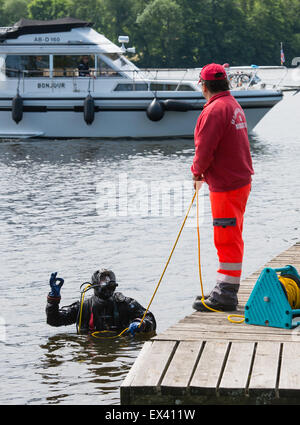 Taucher Heiko Eisenhauer (L) und sein Kollege Uwe Grundmann der Oberflächenwasser Rescue Association SEG Wasserrettung Fläming-Spreewald e.V. des Deutschen Roten Kreuzes nehmen Teil in einem Bohrer im See Krimnick in Koenigs Wusterhausen, Deutschland, 9. Juni 2015 statt. Foto: Patrick Pleul/dpa Stockfoto