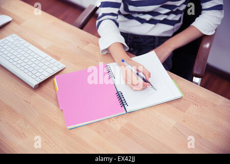 Closeup Portrait einer ungezwungenen Frau Schreiben von Notizen im Büro Stockfoto