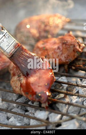 Fleisch auf Grill verglast, mit Pinsel Stockfoto