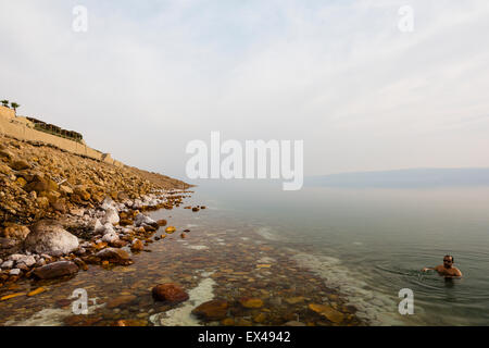 Totes Meer, Jordanien. Einzelnen männlichen Tourist mit seinem ausgestreckten im Toten Meer schweben. Stockfoto