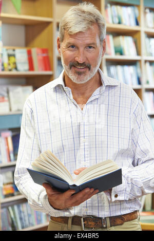 Porträt von männlichen Kunden Lesebuch In Buchhandlung Stockfoto