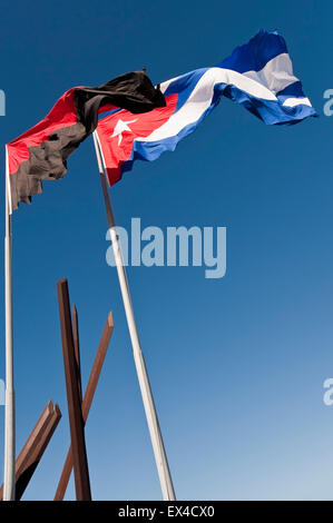 Vertikale Ansicht der Nationalflagge Kubas und der revolutionären Flagge in Santiago De Cuba auf dem Revolutionsplatz Antonio Maceo Stockfoto