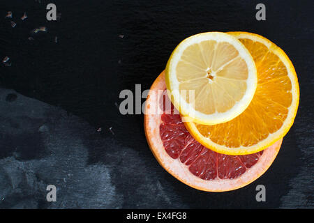 Scheiben von Zitrusfrüchten auf einer Schiefertafel Platte Stockfoto
