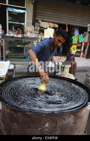 Kairo, Ägypten. 6. Juli 2015. Ein ägyptischer Mann macht die traditionelle arabische Dessert Kanafeh, die häufig während des Heiligen Monats Ramadan, vor einem Dessert-Geschäft in Kairo, Ägypten, am 6. Juli 2015 serviert wird. © Ahmed Gomaa/Xinhua/Alamy Live-Nachrichten Stockfoto