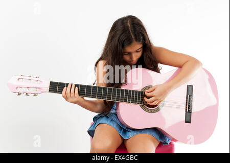 Süße junge Mädchen spielt Gitarre und singt. Stockfoto